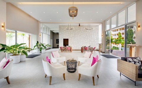 living room with white chairs and pink pillows