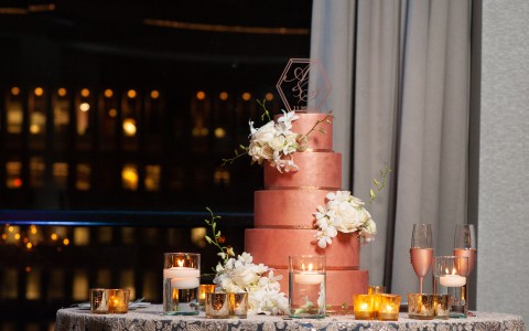 bronze wedding cake with flowers on it, candles in water below