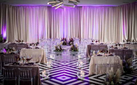 wedding reception area with black and white floor and purple lighting