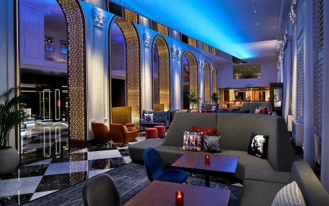 Dining area with grey seating golden arches and a high ceiling with blue lights