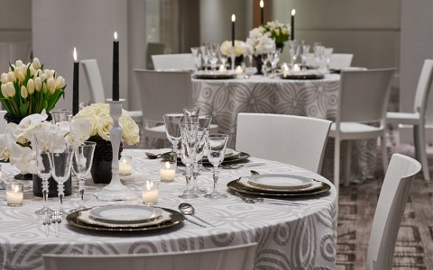 silver and white table cloths with white floral centerpieces 