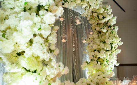 flower arch with candles in bubbles hanging from the center