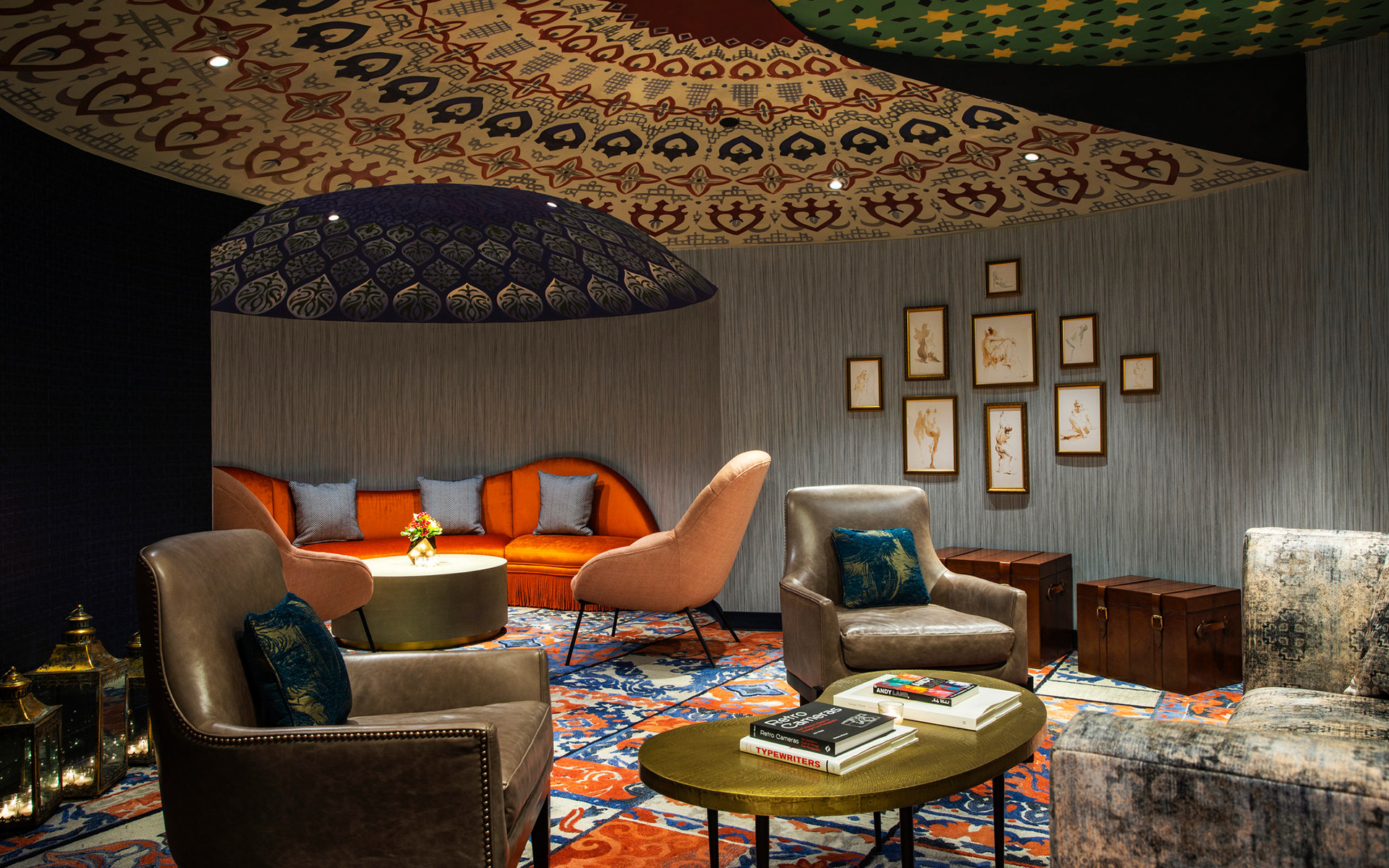 seating room with orange couch, gray chairs, and patterned ceiling