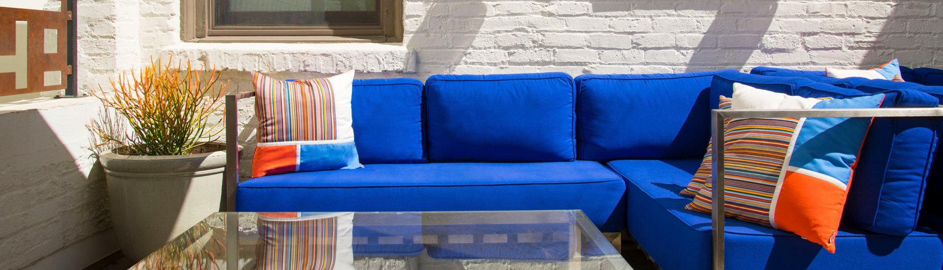 blue couch with colorful pillows on a patio