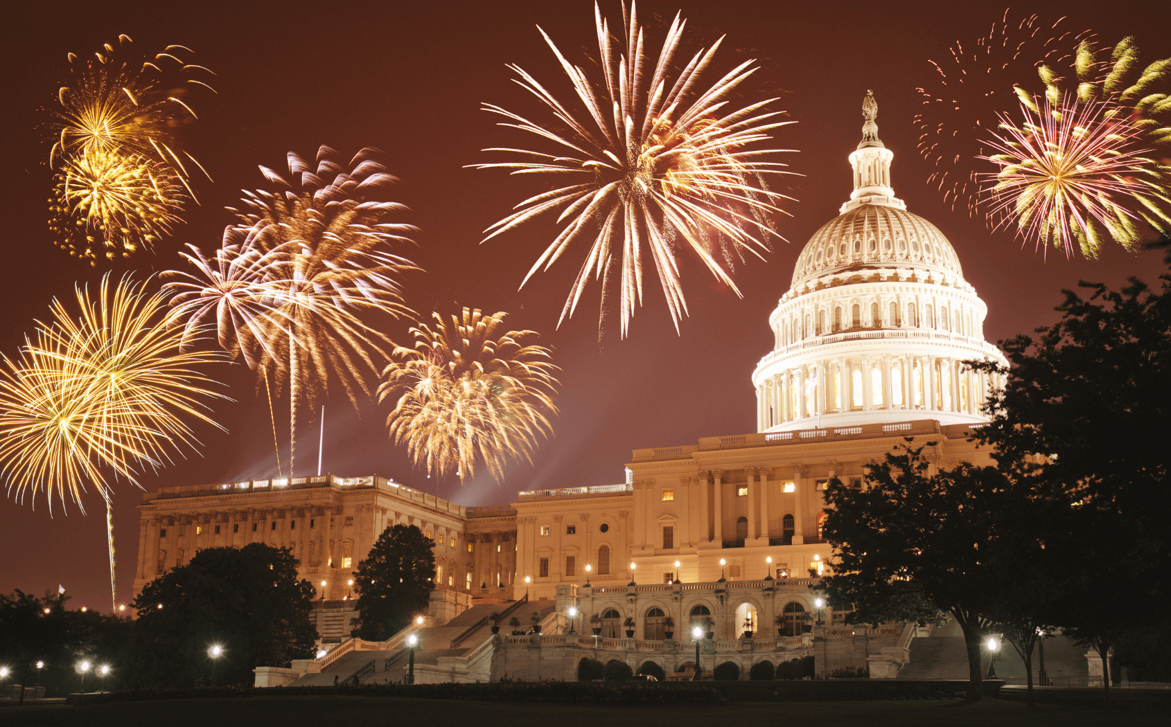 View of the US capitol with fireworks around it 