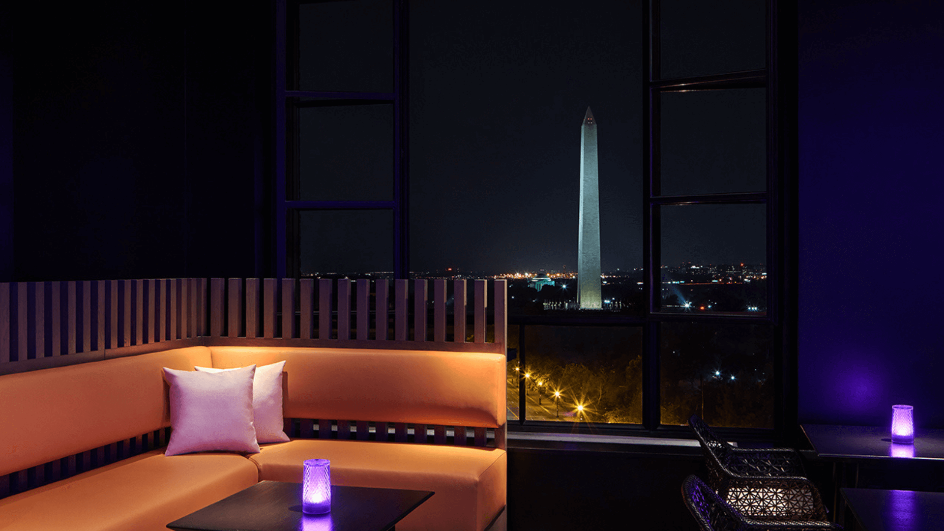 orange couch and a view of the washington monument at night