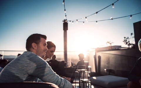 two guys at the rooftop bar sitting looking at someone