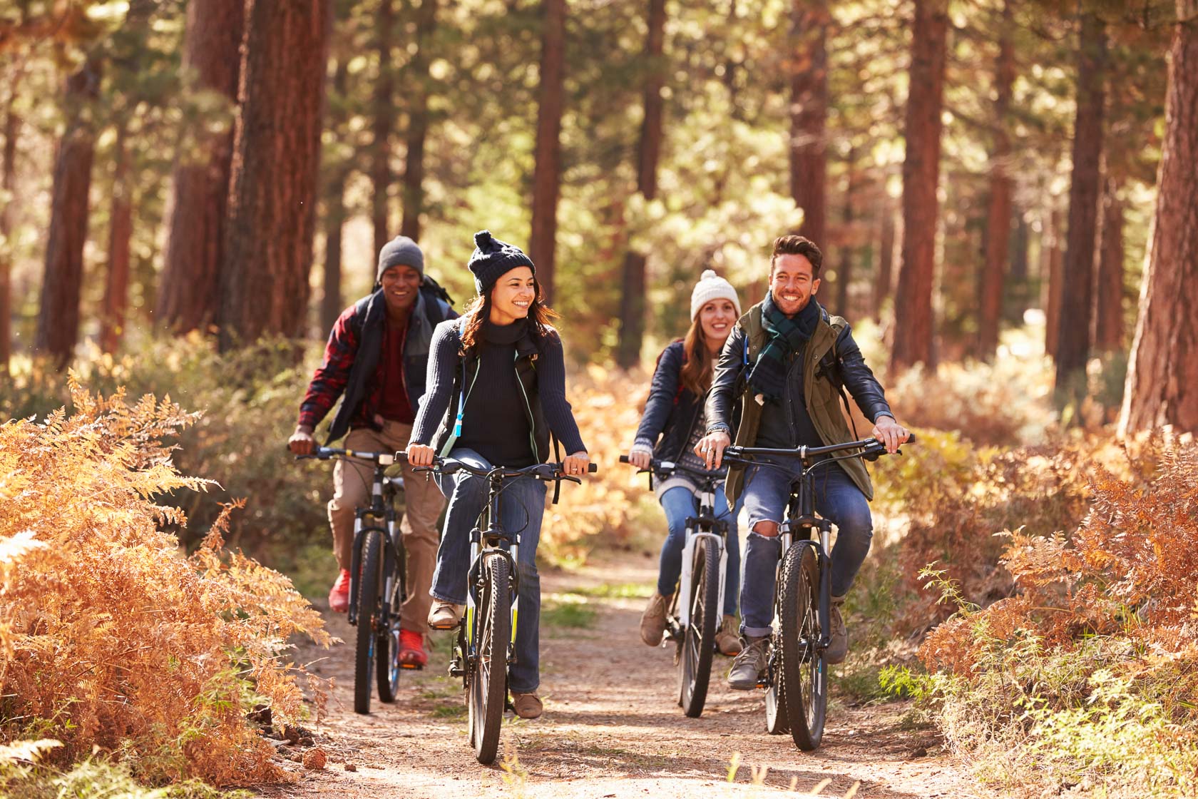 4 people riding a bike in a forest