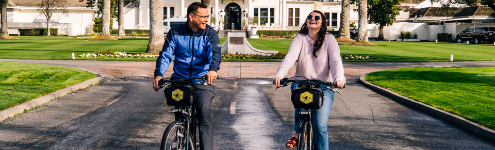 man and woman riding bikes next to each other and laughing 