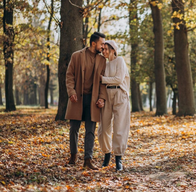 couple walking through fall forest