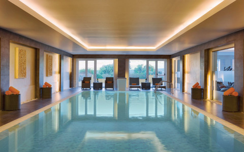 Indoor pool with lounge chairs and orange towels