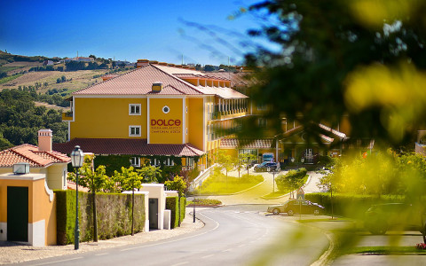 Yellow hotel building with blurred tree leaves in foreground