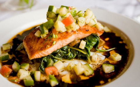 Salmon on bed of spinach and diced vegetables