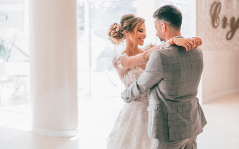 Man dancing with woman wearing wedding dress