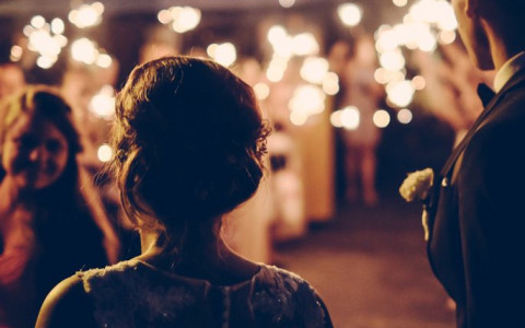 Bride and groom in front of a crowd at night