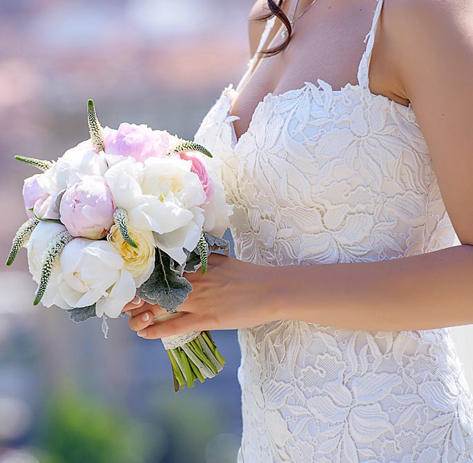 woman in a wedding dress holding a bridal bouquet