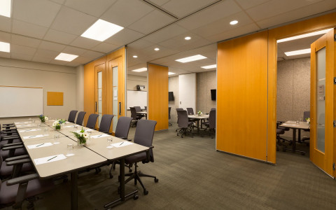 room with tables and chairs set up for meetings 