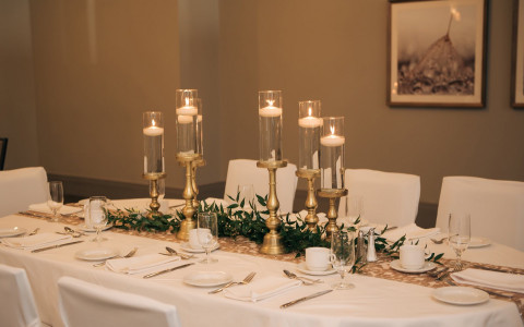 white table with candles and greenery