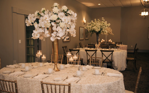 white table cloth with tall flower arrangements