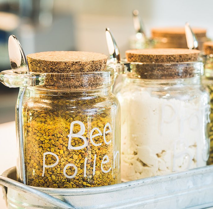 closeup of two mason jars and one has bee pollen in it