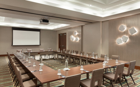 A large square table has a large amount of seating and a projector