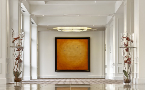 hotel hallway with orange painting on wall 