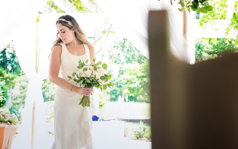 A bride holding a bouquet of flowers on a sunny day | Image Credit: Alyson Ridge