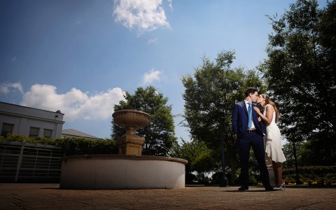 A bride and groom kissing outside by a fountain | Image Credit: Alyson Ridge