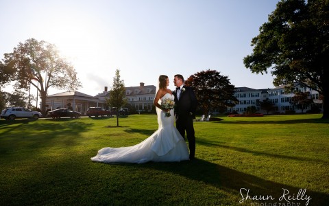 bride and groom looking into each other's eyes during golden hour on the front lawn of Seaview, a Dolce Hotel