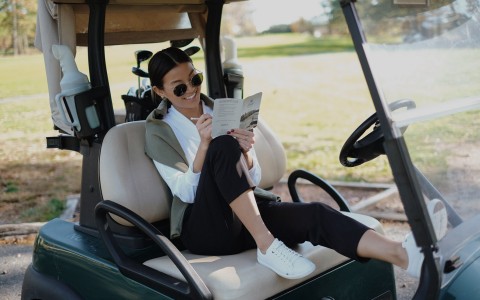 woman in golf cart, keeping score