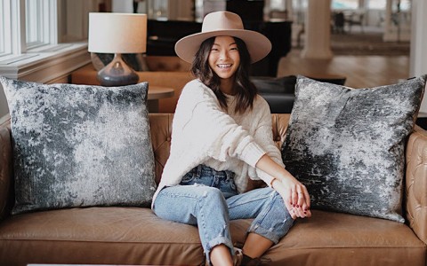 woman wearing a hat sitting on couch smiling