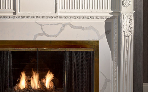 a fireplace in the main area of a hotel that has a fire lit