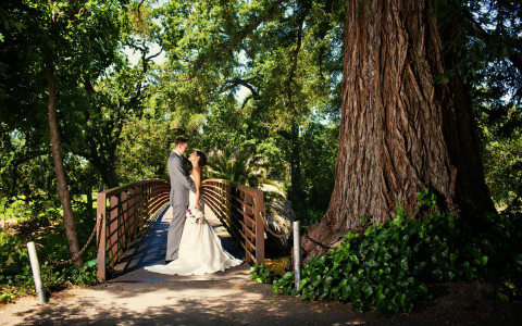 Stunning photo of a bride and groom at one of our bridges surrounded by Redwood and Oak trees