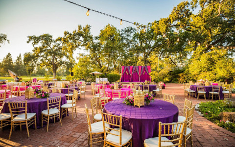 Table and stage setup with a pink and purple theme for an Indian Wedding at one of Silverado's outdoor venues.