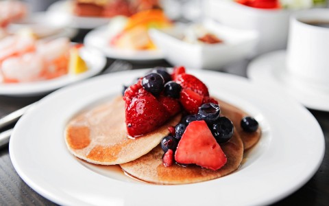 pancakes with strawberries, blueberries, and syrup