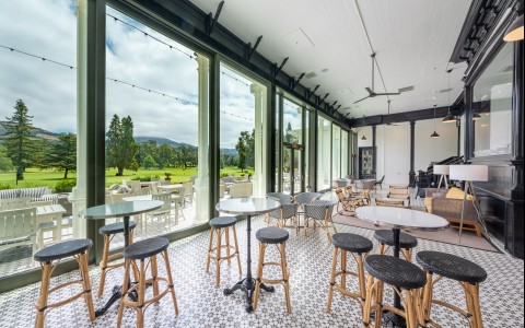 Bar stool seating with floor to ceiling windows that display our golf course.