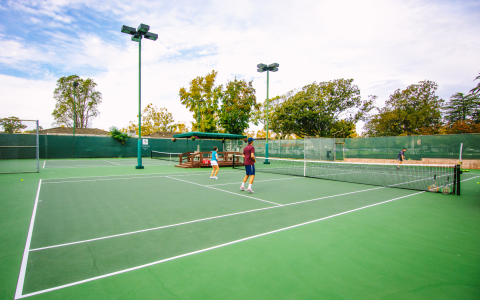 Players outside on the tennis courts preparing for a game