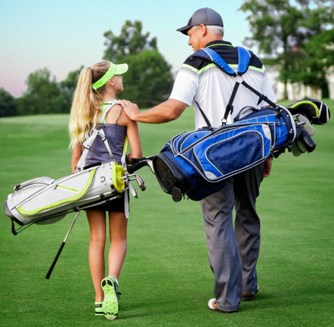 teenager girl with a golf bag with a man also with a golf bag on the best golf course in Napa