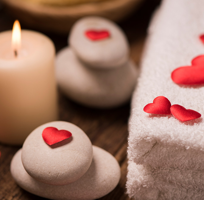 spa stones and towels with rose petals 
