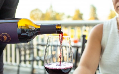 Wine being poured to a resort guest to sip and enjoy out on The Grill patio