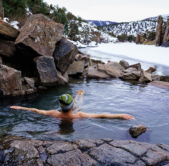person in a thermal water wearing a knitted hat 