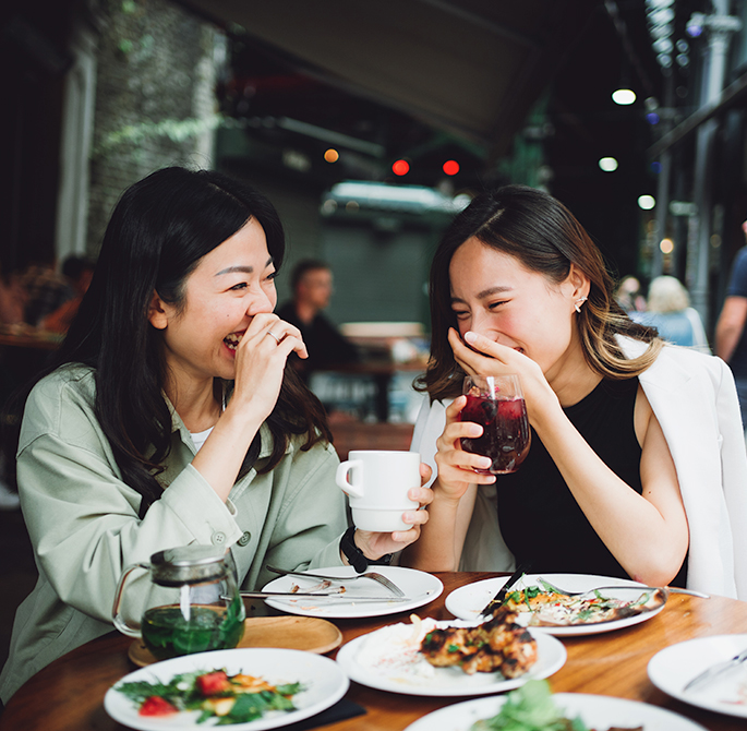 two woman eating and drinking at a restaurant