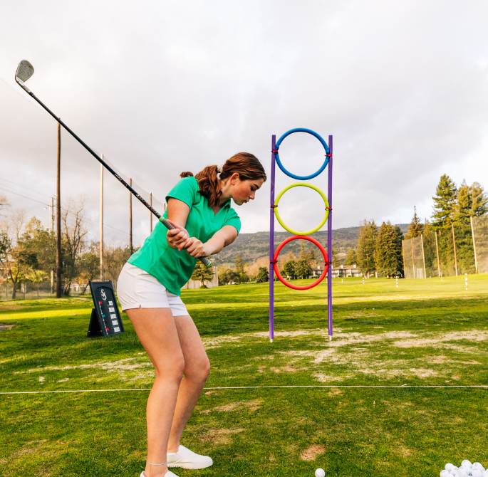 girl swinging a golf club 