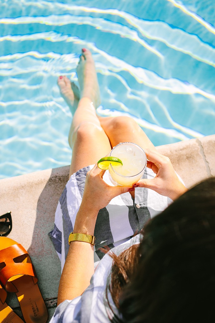Resort guest enjoying a cocktail while lounging at the pool