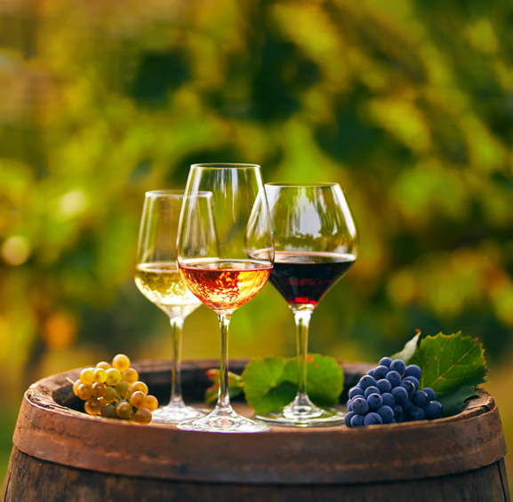glasses of red, rose, and white wines with grapes