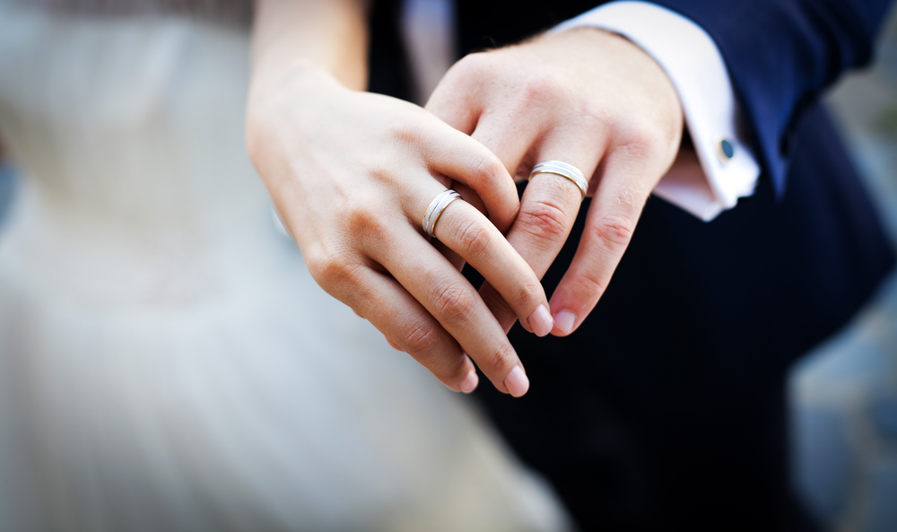 man and woman with wedding rings on their hands
