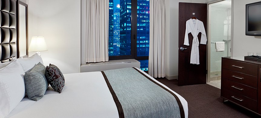 Room with double bed and robe hung on door