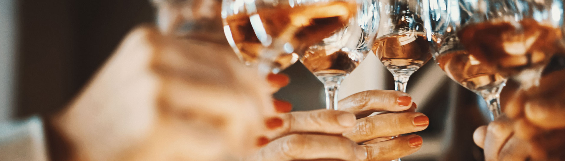 close up of glasses of wine being held up together for a cheers