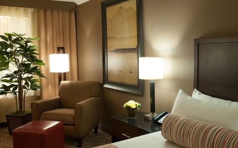 Airtel hotel room seating area with chair, ottoman and lamp