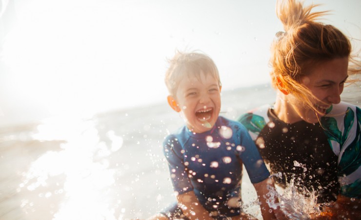 mother and son splashing in waves